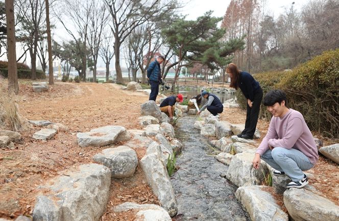 공단 직원들이 인천둘레길 9코스 주변에 개방한 실개천형 연못을 둘러보고 있다.